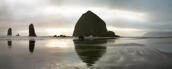 Mid summer evening view of Haystack Rock,  the Needles and beachcombers at Cannon Beach; location for the film: The Goonies