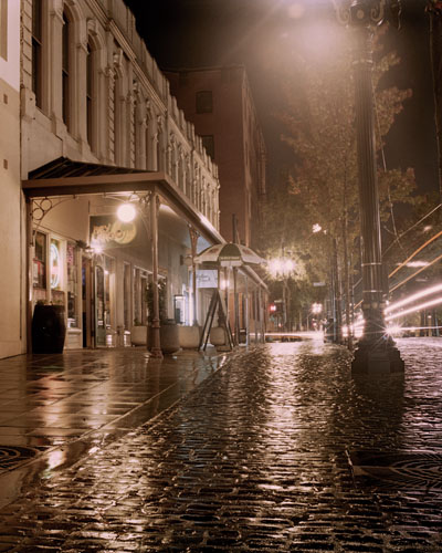 Rainy evening in old town Portland.  The Max Train passing by over the cobblestones