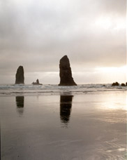 Mid summer evening view of Haystack Rock,  the Needles and beachcombers at Cannon Beach; location for the film: The Goonies