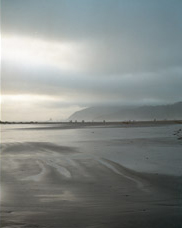 Mid summer evening view of Haystack Rock,  the Needles and beachcombers at Cannon Beach; location for the film: The Goonies